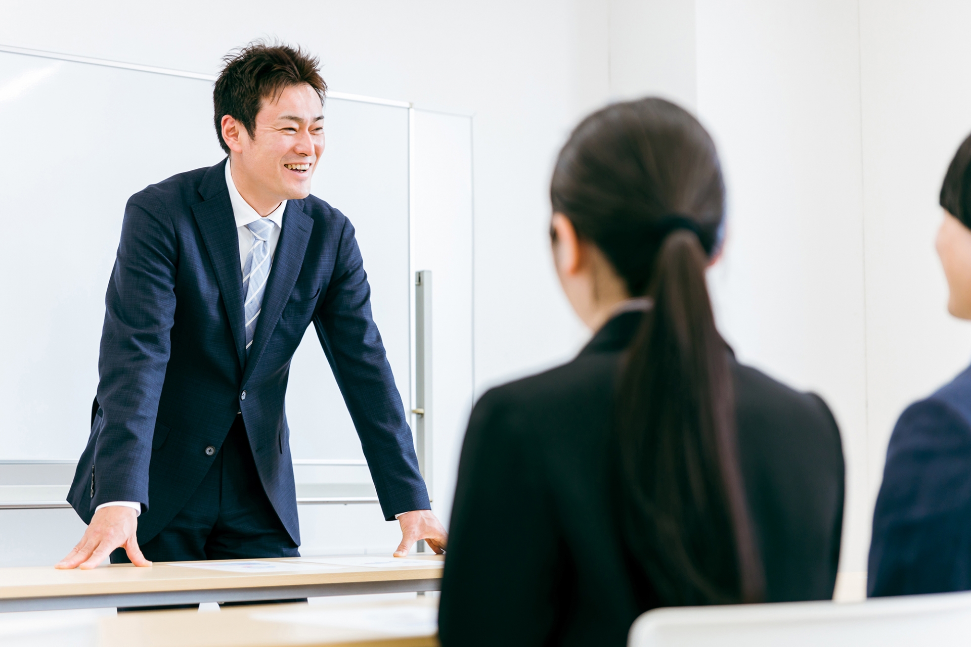 セミナーをする笑顔のスーツ姿の先生・教師